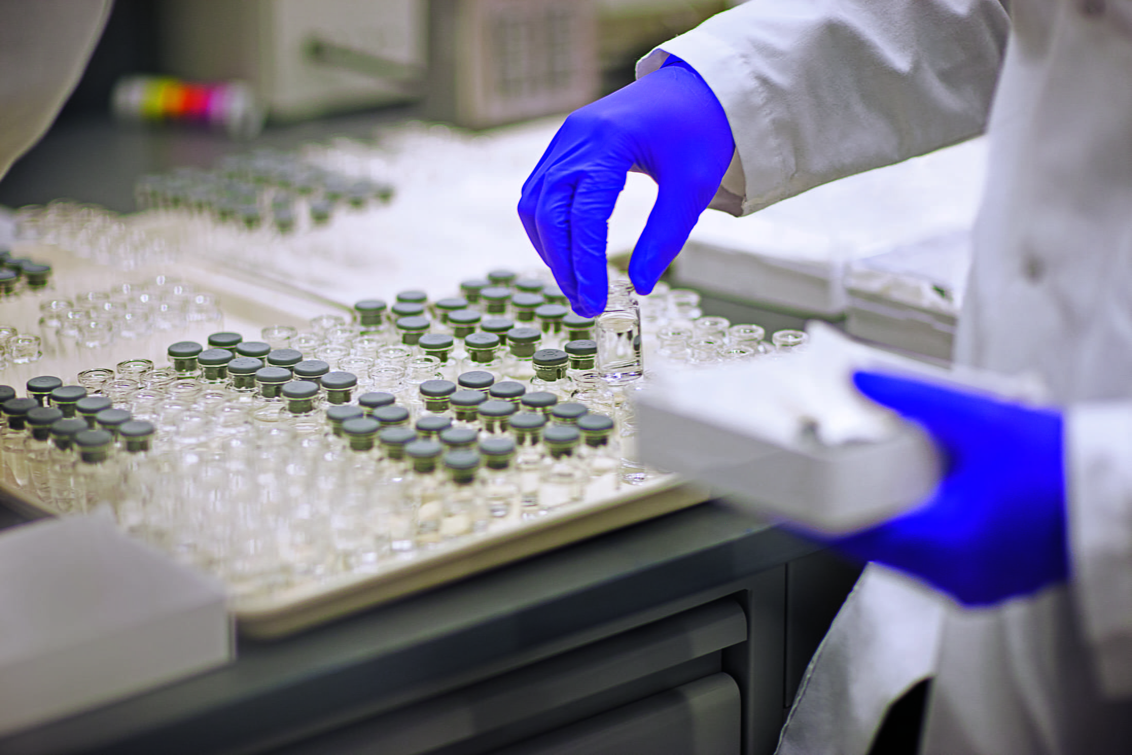West scientist picking up container in the lab