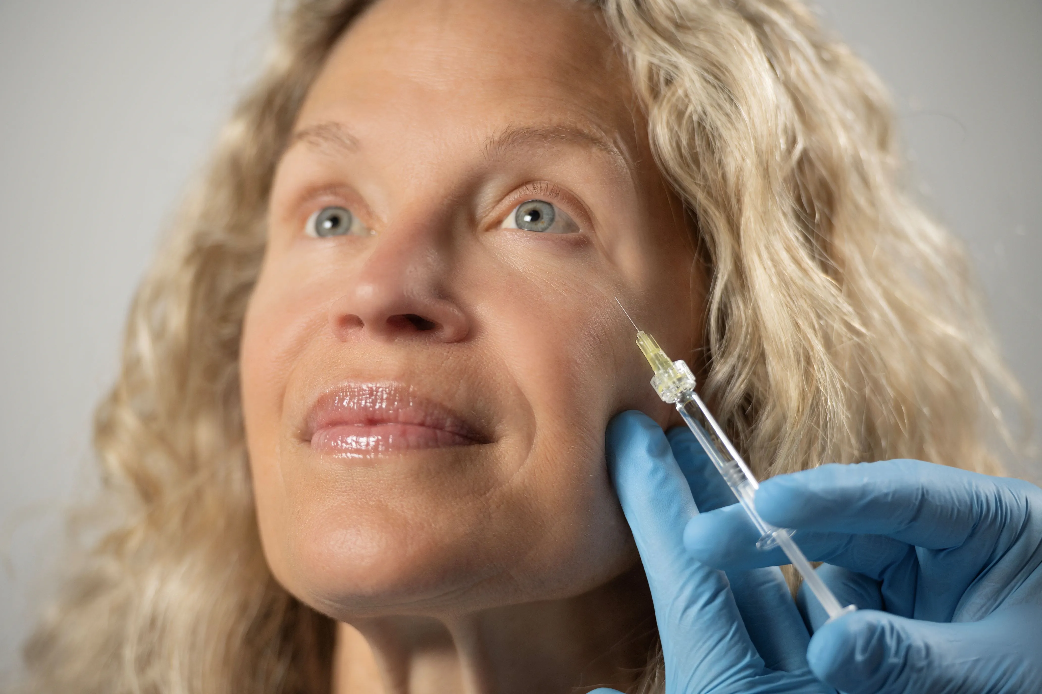 Clinician preparing an intravitreal injection using a syringe with a Luer connection for ophthalmic drug delivery.