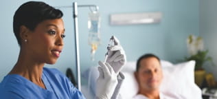 Nurse holding syringe and vial with patient