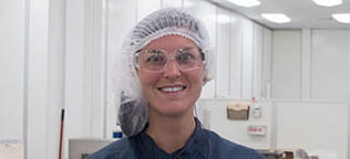 Gowned Employee smiling into the camera