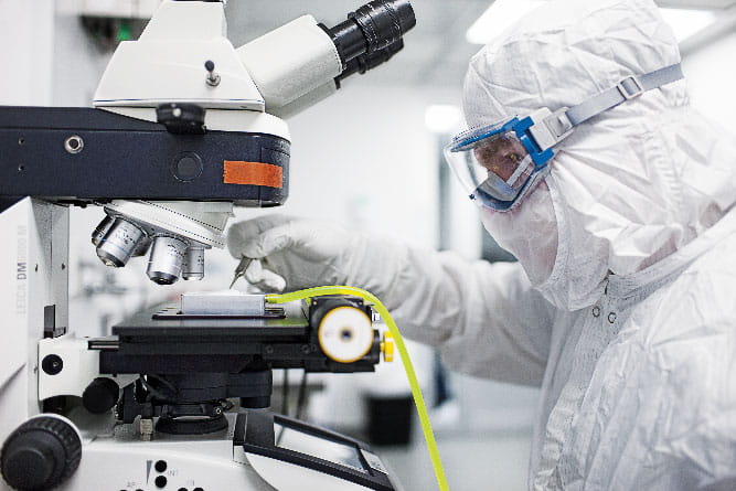 Scientist placing filter on microscope platform for particle analysis