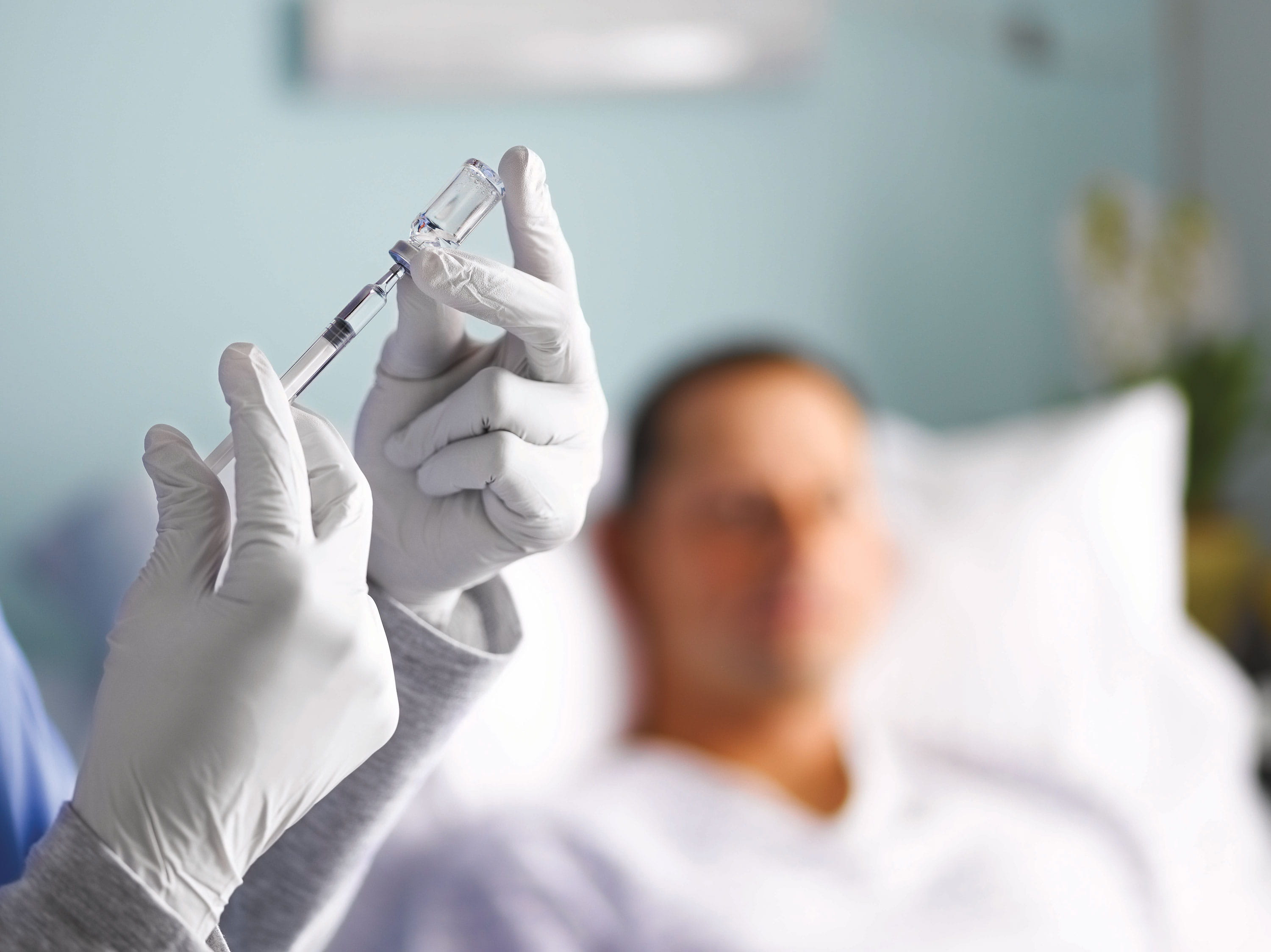 Healthcare professional preparing injectable vial